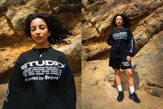 Supervsn Studios Model posing at the canyon in black hoodie and black shorts with white text on it.
