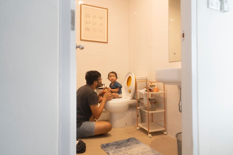 A dad potty trains his child at night.