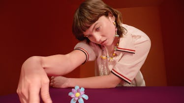 Isadora Bjarkardóttir Barney looking at a sculpture of a flower in a Miu Miu campaign