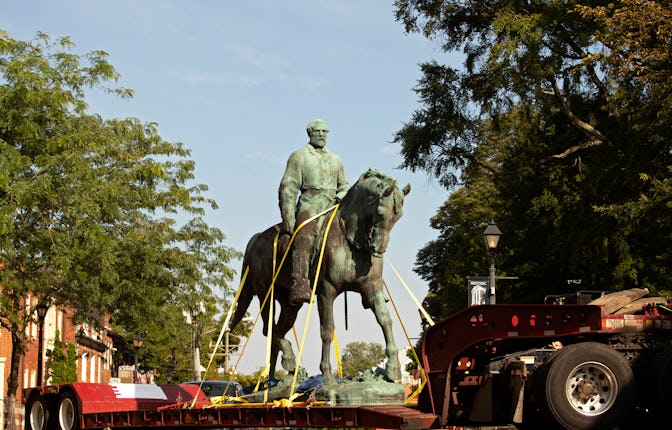 Workers remove the statue of Confederate general Robert E. Lee from a park in Charlottesville, Virgi...