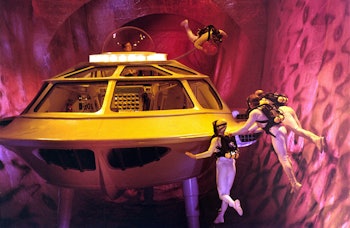 A yellow submarine with people diving around it in the 'Fantastic Voyage'