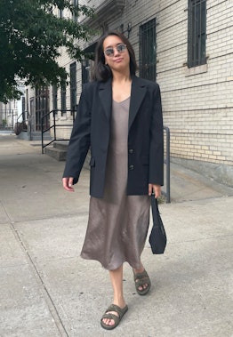 Marina Liao wears an oversized black blazer over a soft brown slip dress with a bob haircut.