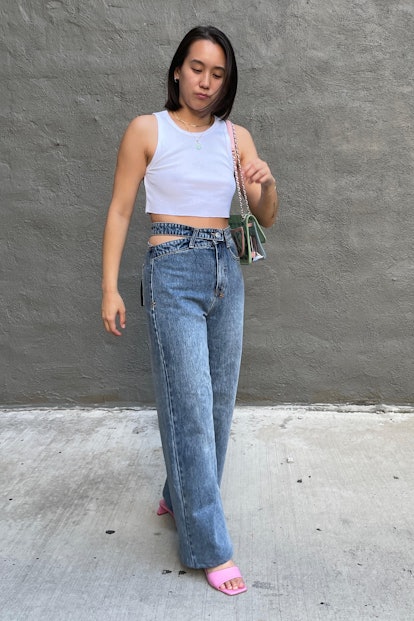 Marina Liao wears flared denim pants with cutouts at the hips, paired with a white tank top and bob ...