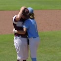 A Little League player comforts a pitcher after he hit him in the head with a fastball.