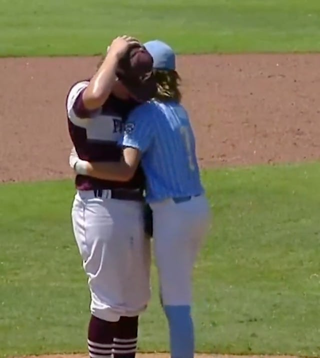 A Little League player comforts a pitcher after he hit him in the head with a fastball.