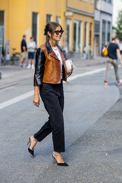 Darja Barannik wears a Louis Vuitton bag and a brown black jacket with denim jeans from A.Roge H...