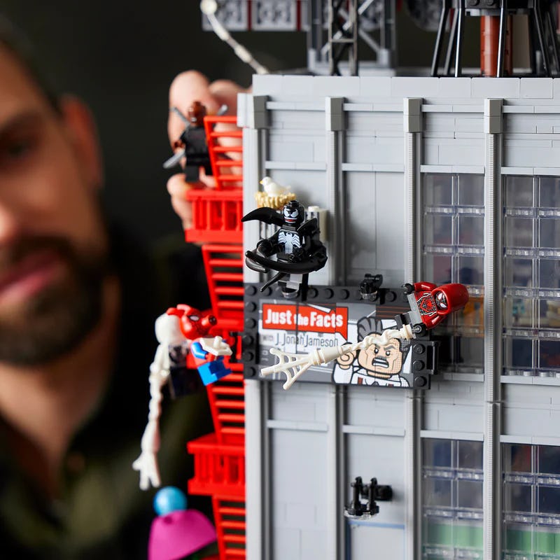 A man playing with a massive Lego set