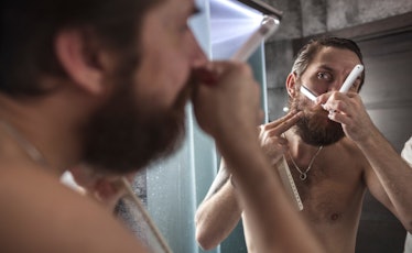 Man with sensitive skin shaving his beard with a razor.