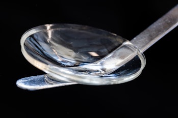 Clear, concave disk placed on top of a flattened metal wire 