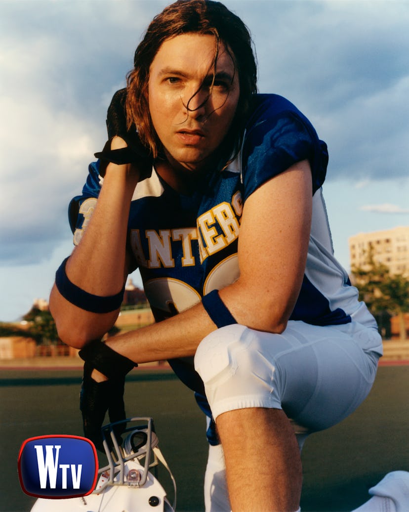 Nicholas Braun as Tim Riggins in a rugby uniform posing on one knee