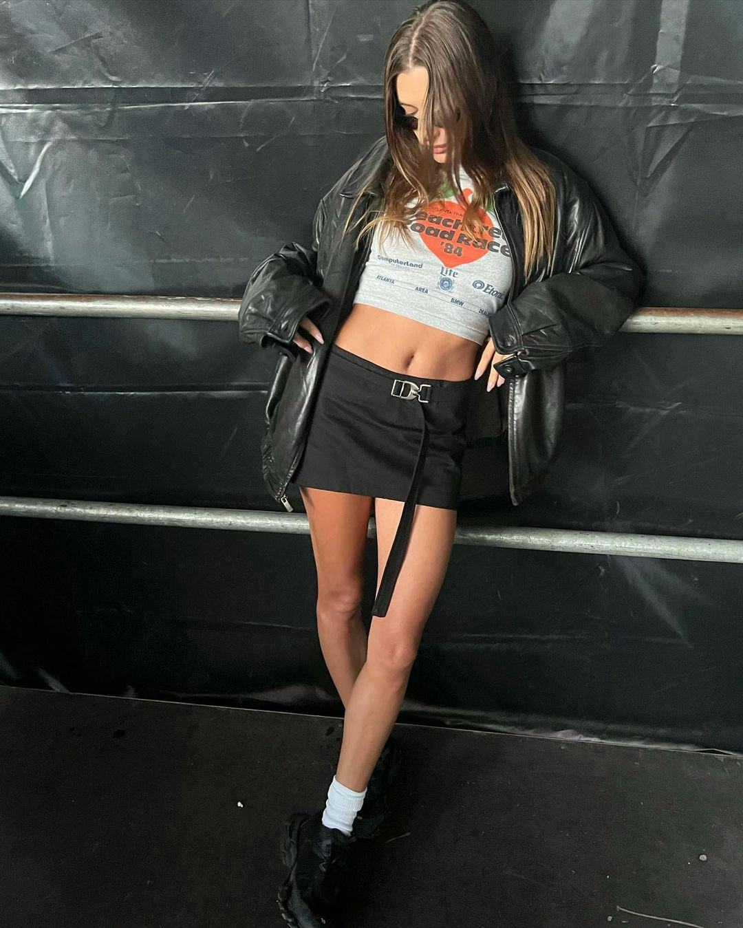 hailey bieber wearing a black mini skirt with a cropped tee, an oversized leather jacket and white s&hellip;