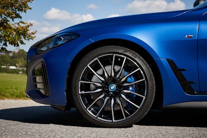 A close up of a The inside of a A blue BMW i4 eDrive Gran Coupe and its front wheel