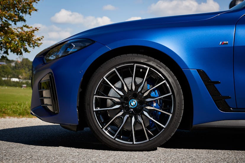 A close up of a The inside of a A blue BMW i4 eDrive Gran Coupe and its front wheel