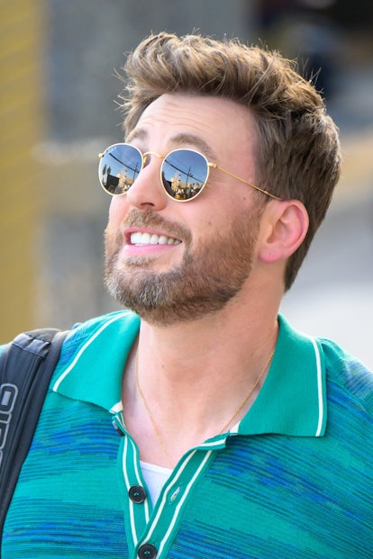 Chris Evans in sunglasses with a greying beard in a striped blue dress shirt
