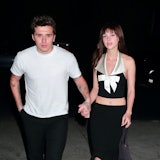 Nicola Peltz walking with her husband, Brooklyn Beckham, wearing black satin platform pumps