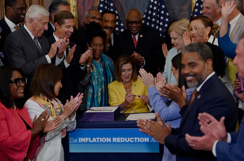 Lawmakers applaud after Speaker of the House Nancy Pelosi signed the Inflation Reduction Act after t...
