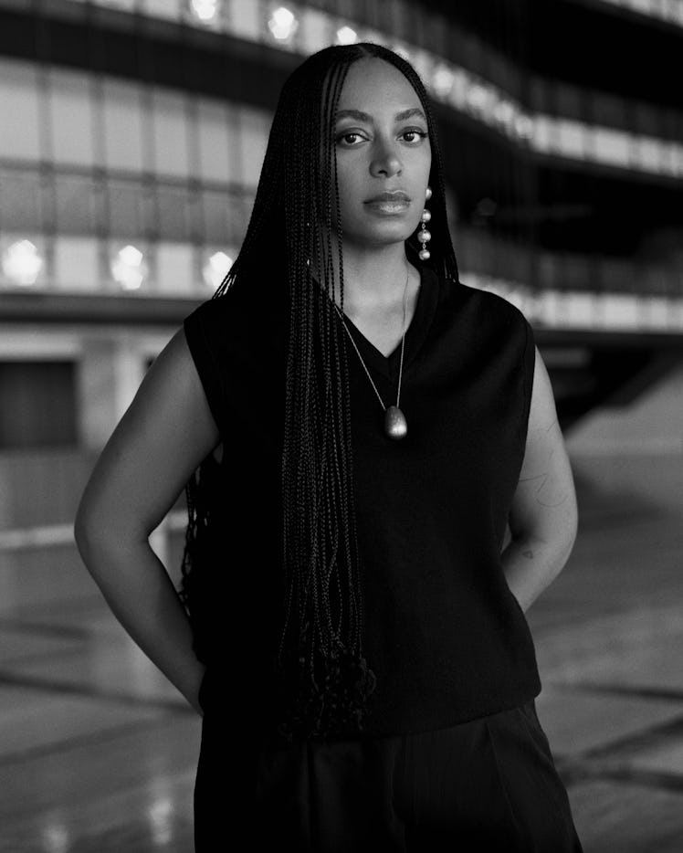 Solange Knowles wearing a black V-neck and statement jewelry