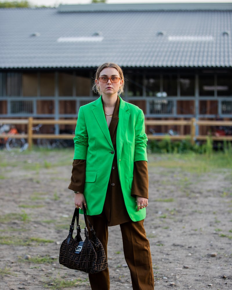  A guest is seen wearing brown suit, green blazer, Fendi bag outside Henrik Vibskov