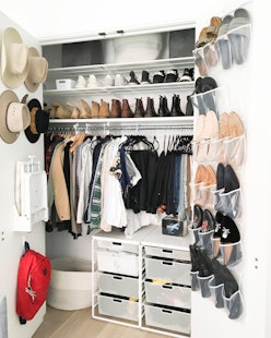 A walk-in closet with different organizational bins and hangers on the doors