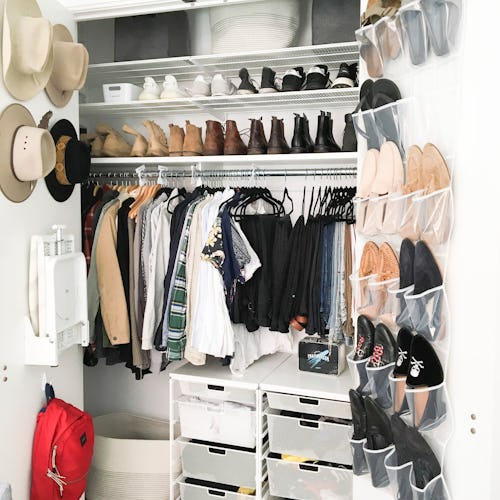 A walk-in closet with different organizational bins and hangers on the doors