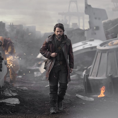 Cassian Andor (Diego Luna) walking through the debris in a war zone in the show Andor