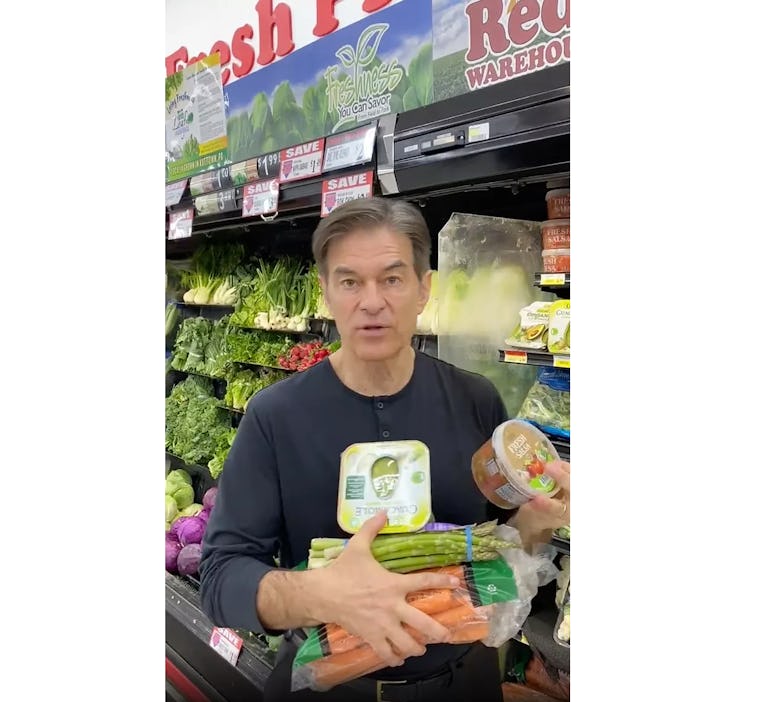 Dr. Oz in a grocery store holding health food.