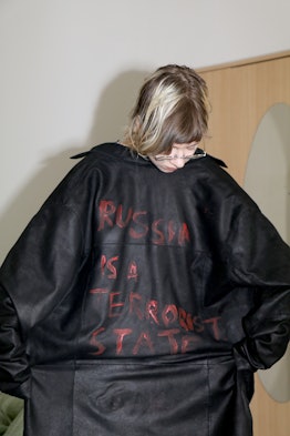 A person wearing a jacket that reads "Russia is a terrorist state"