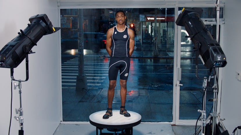 A man posing in Telfars new Olympic-worthy sportswear line wearing black shorts and a shirt with a w...