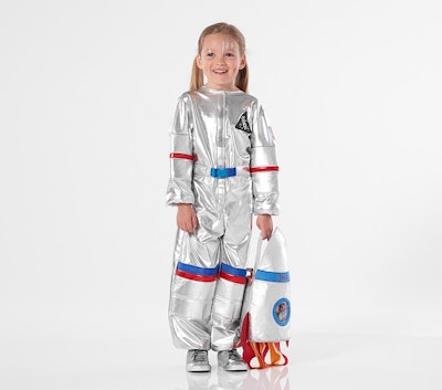 A blonde child in pigtails wearing a silver astronauts uniform with a monogramed trick or treat bag ...