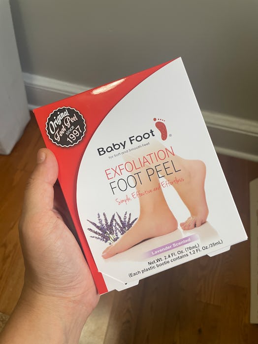Woman holding Baby Foot Peel box. 