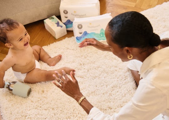 A new mom playing with her baby on the rug of the bedroom 