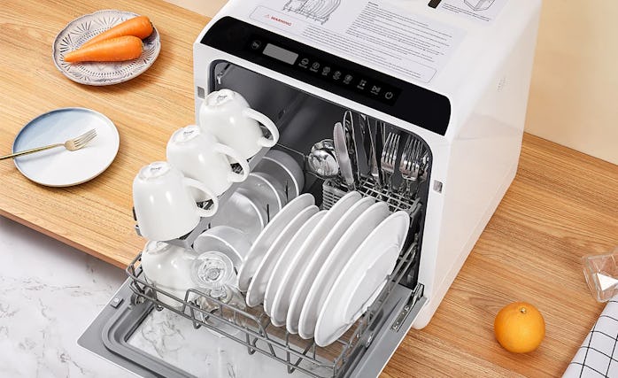 Fully loaded Hava R01 dishwasher with plates, bowls, mugs, and utensils.