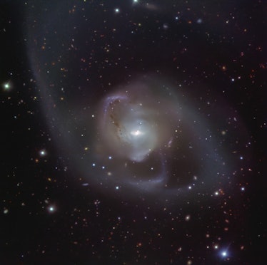The galaxy NGC 7727, shrouded in lopsided arms of dust and has two bright nuclei in the center