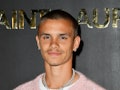 Romeo Beckham wears a pastel pink shirt ahead of dyeing his hair pastel pink.