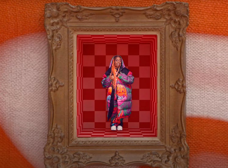 A mini Missy Elliott standing in a picture frame