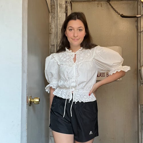 A woman wearing a white shirt top and black athletic shorts