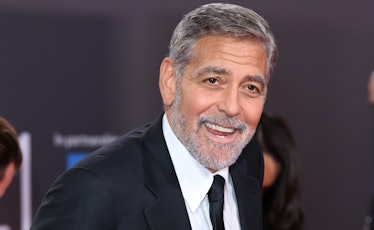 George Clooney with grey hair and beard in a formal suit