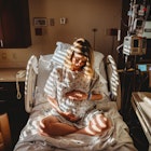 A pregnant woman sitting in a hospital bed.