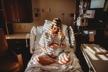 A pregnant woman sitting in a hospital bed.