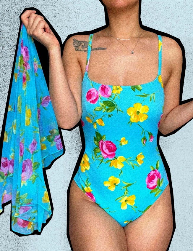 A girl with a tattoo on her right shoulder in vintage swimwear, a blue one-piece with a flower patte...
