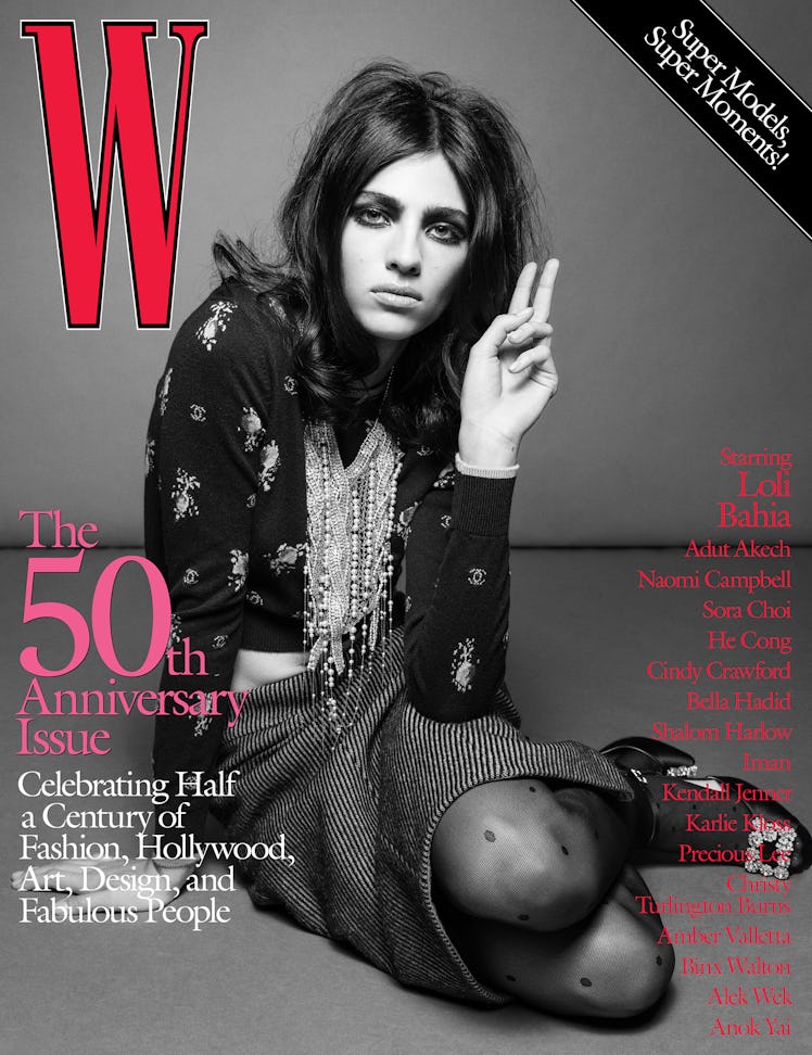 Loli Bahia in a blouse, skirt, necklace, and thights on the cover of W Magazine's 50th anniversary i...