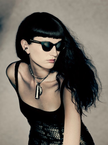A black-haired model wearing sunglasses in an Alexander McQueen campaign