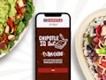 iPhone on a dining table with the Chipotle app opened, in the middle of two Chipotle dishes.