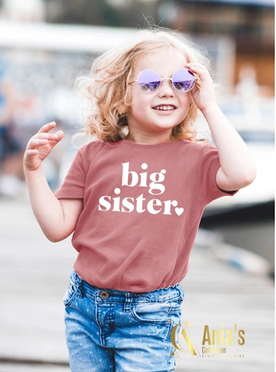 little girl wearing sunglasses and big sister shirt
