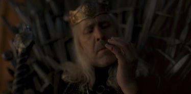 Paddy Considine's King Viserys I Targaryen looks at his hand in House of the Dragon Episode 1