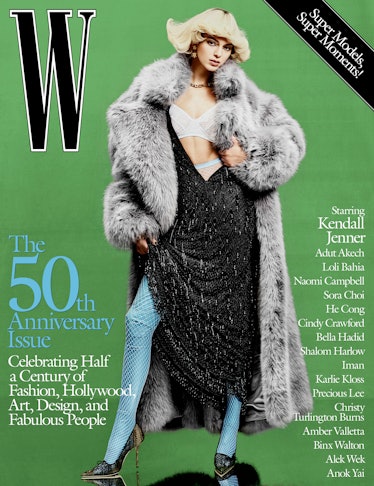 Kendall Jenner on cover of W Magazine in a grey fur coat, black dress, and blue fishnets 