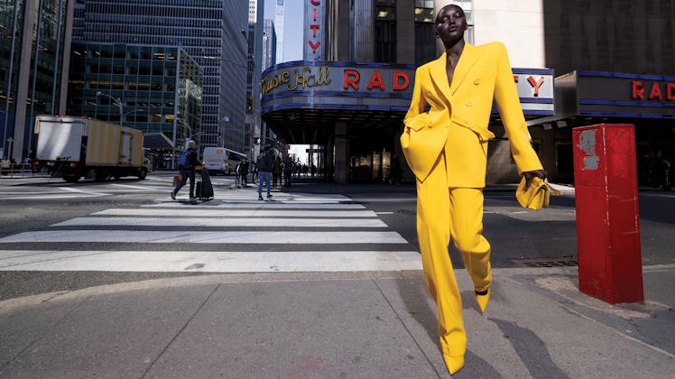 Adut Akech wearing a bright yellow suit in a Michael Kors campaign