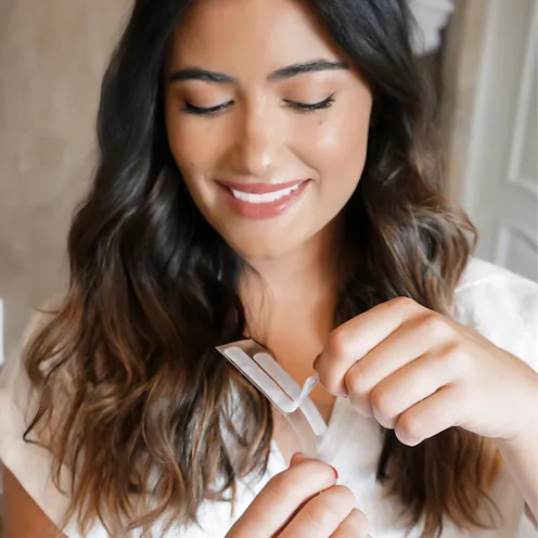 Girl using Crest 3DWhitestrips foolproof teeth whitening routine