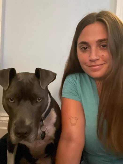 The writer showing the tattoo of her dog, next to her dog