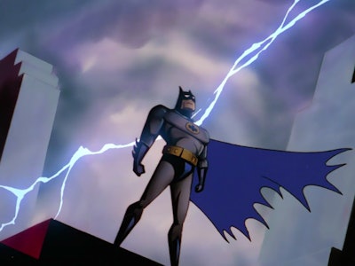 Batman standing on a rooftop with lightning behind him in Batman: Caped Crusader